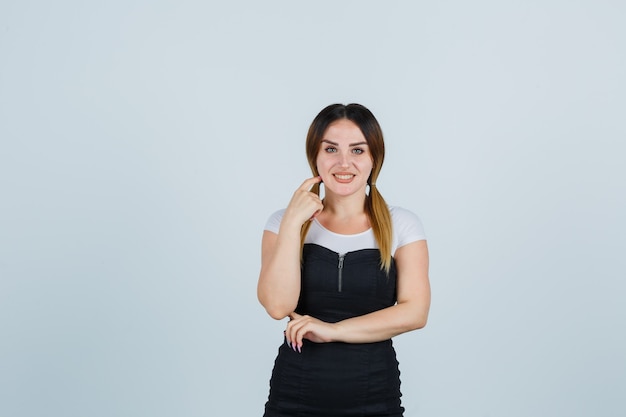 Blonde young lady in dress gesturing isolated