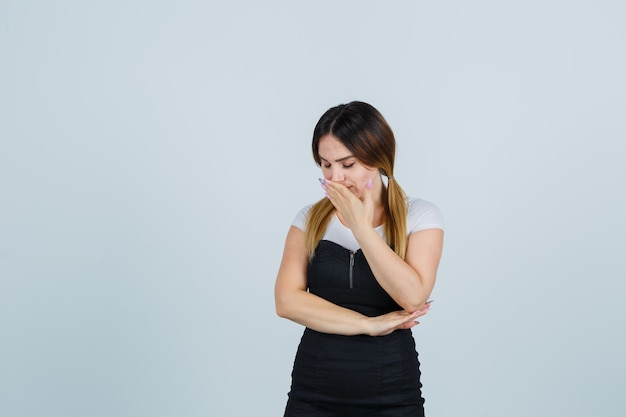 Blonde young lady in dress gesturing isolated