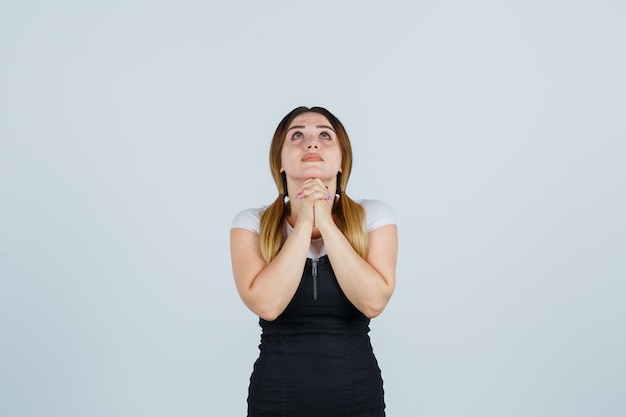 Blonde young lady in dress gesturing isolated