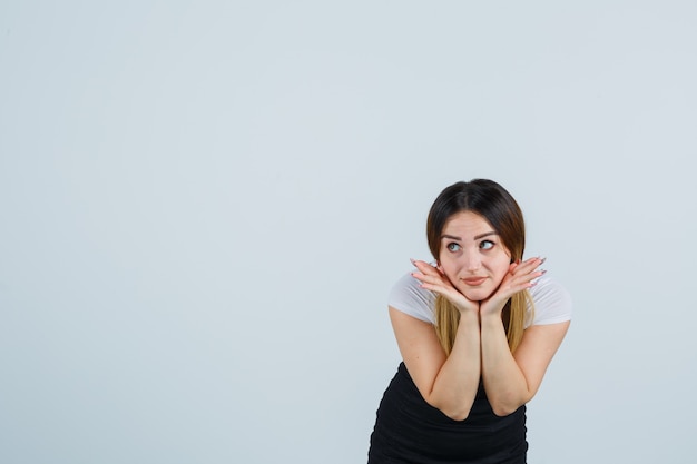 Giovane signora bionda in vestito che gesturing isolato