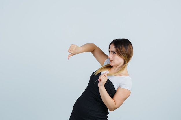 Blonde young lady in dress gesturing isolated