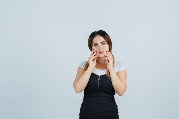 Blonde young lady in dress gesturing isolated