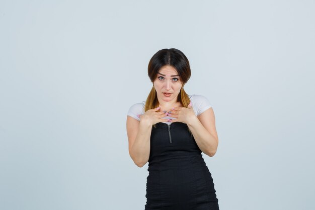 Blonde young lady in dress gesturing isolated