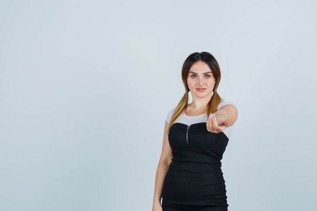 Giovane signora bionda in vestito che gesturing isolato