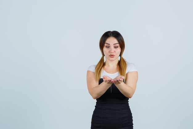 Blonde young lady in dress gesturing isolated