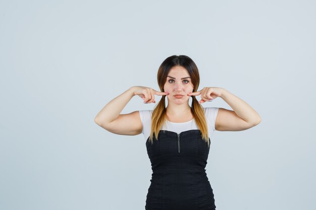 Blonde young lady in dress gesturing isolated