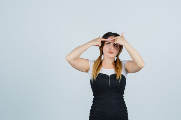 Giovane signora bionda in vestito che gesturing isolato