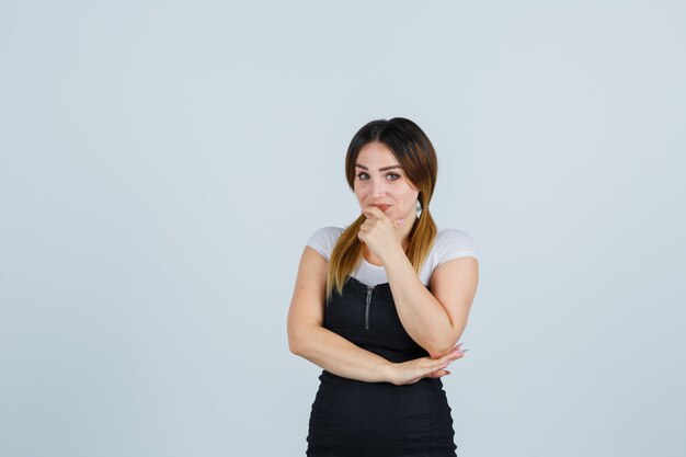 Blonde young lady in dress gesturing isolated