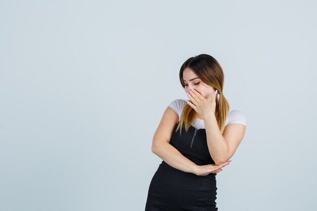 Blonde young lady in dress gesturing isolated