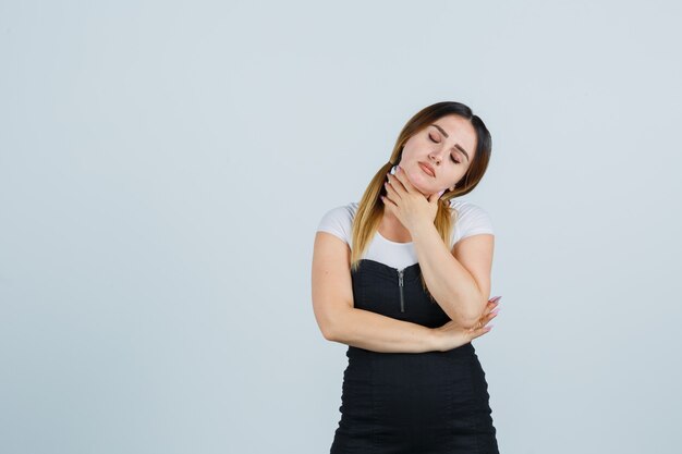 Blonde young lady in dress gesturing isolated