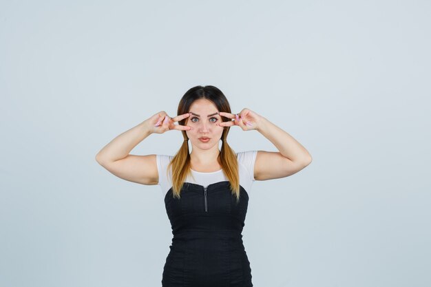 Blonde young lady in dress gesturing isolated