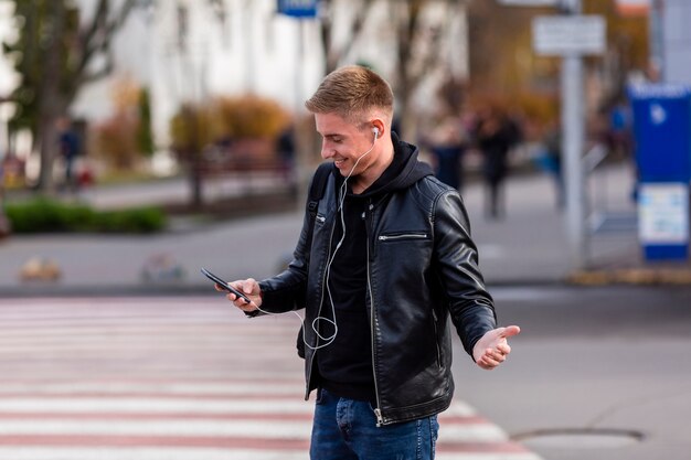 Blonde young man listening to music on earphones