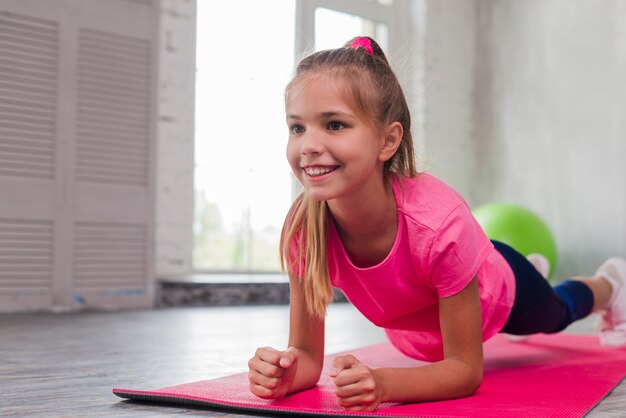 Blonde young smiling girl doing fitness exercise