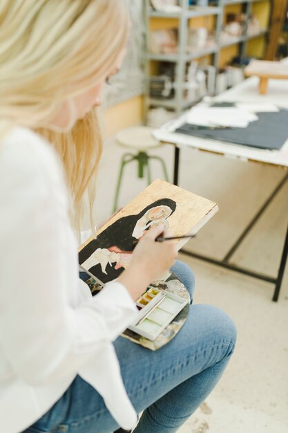 워크숍에 앉아 스케치 그림 금발의 젊은 여자