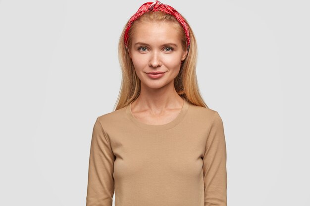 blonde young woman posing against the white wall