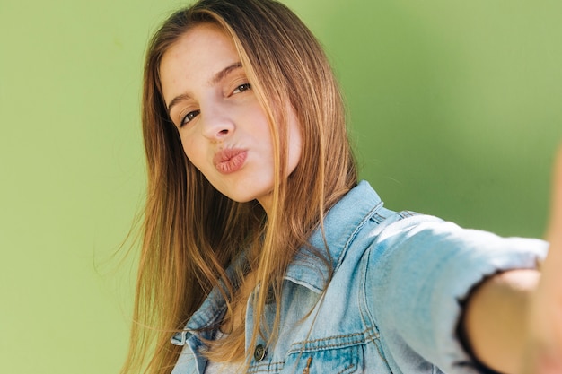 Foto gratuita selfie di presa bianco sporgente le labbra della giovane donna bionda sul telefono cellulare