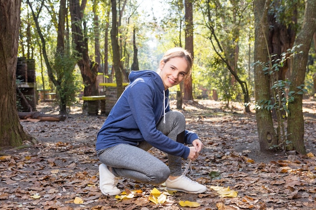 Blonde young woman tying her shoelaces