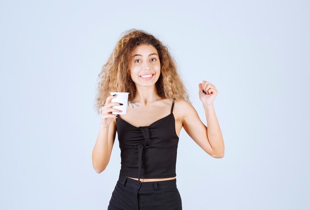 Blondie girl holding a coffee cup as a morning routine. 