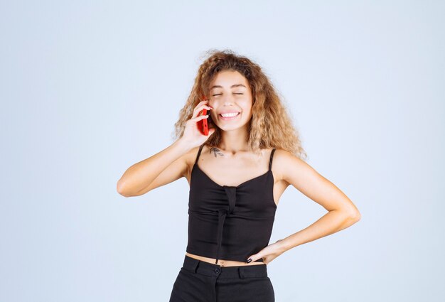 Free photo blondie girl talking to her phone and smiling.