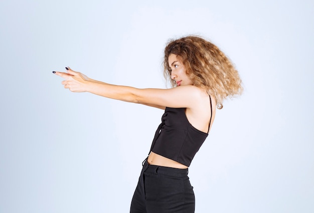 Free photo blondie woman showing gun sign in the hand.