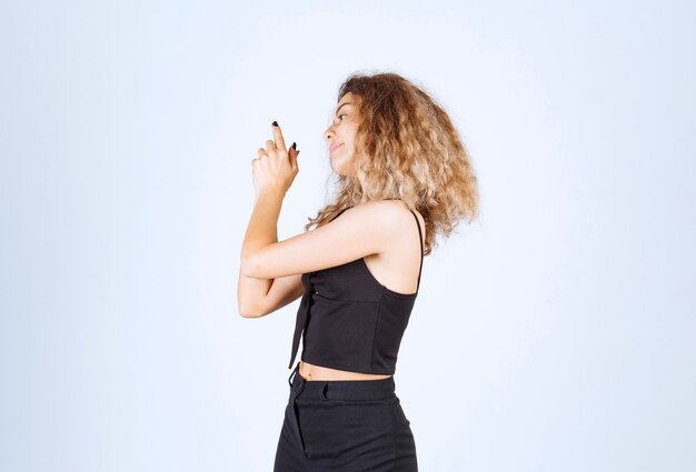 Blondie woman showing gun sign in the hand.