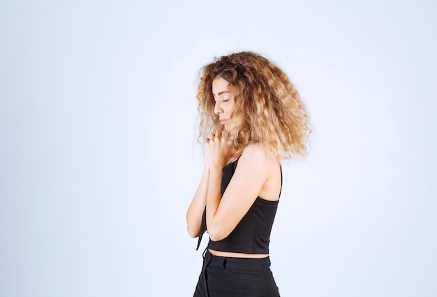 Foto gratuita donna bionda che unisce le mani e prega.