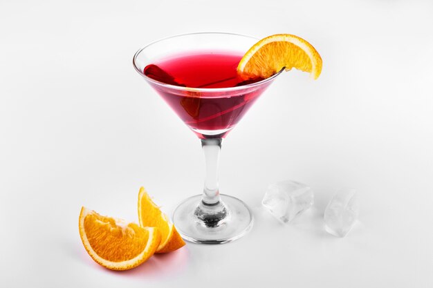 血のオレンジジンとトニックのカクテルは、ガラスのオレンジのスライスを添えて