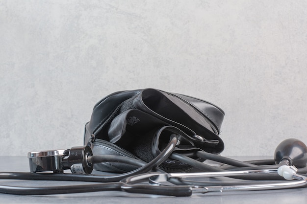 Blood pressure meter and stethoscope on marble table.