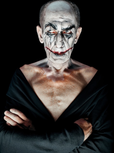 Бесплатное фото Тема кровавого хэллоуина: безумное лицо маньяка на темной студии