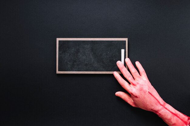 Bloody hand on chalkboard