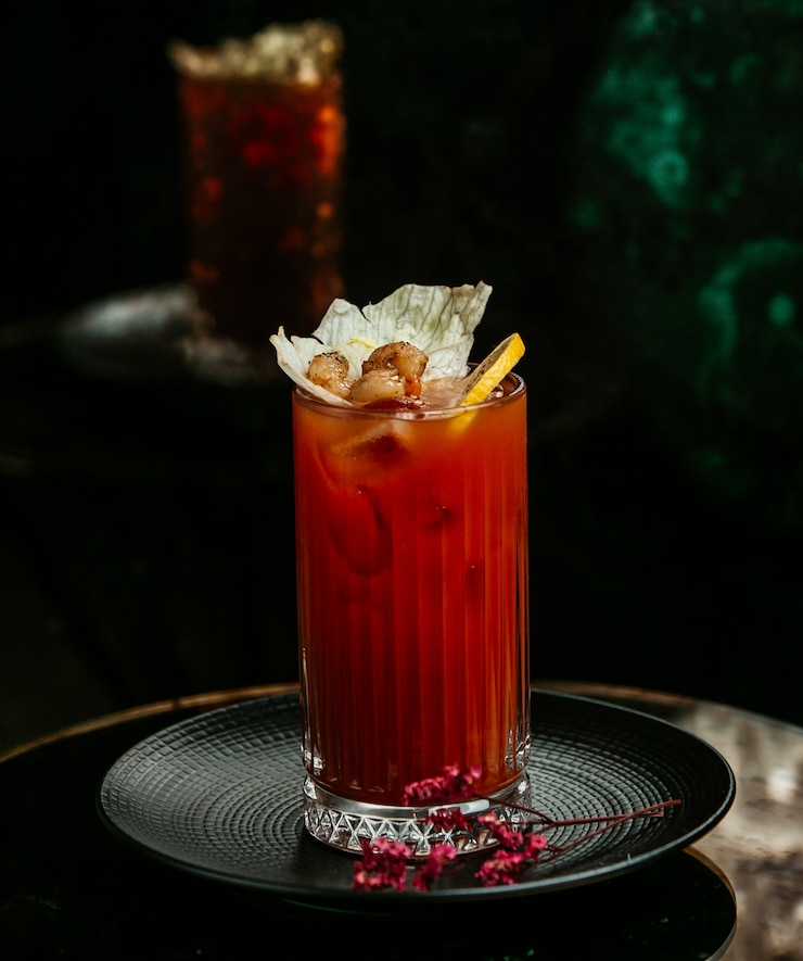 Free Photo bloody mary cocktail with lemon, green olives and tomato sauce.