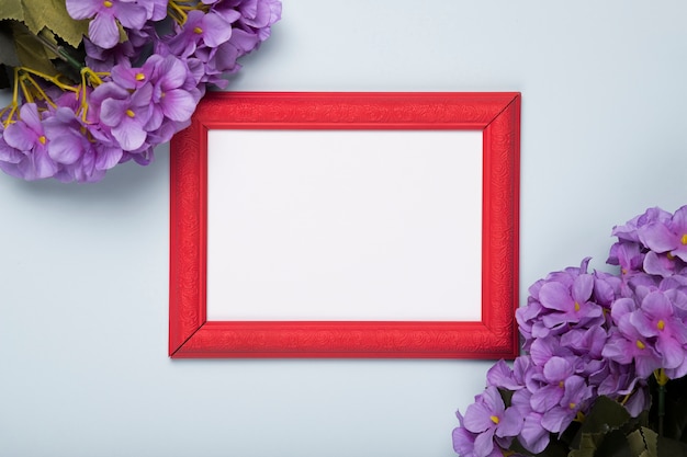 Blooming flowers with frame on table