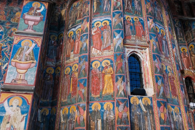 Blue artistic paintings on a religious transilvanian romanian monastery built in a rustic style