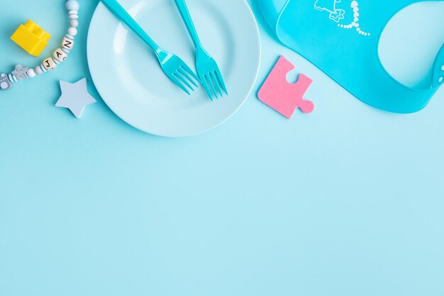 Blue baby plate with cutlery on table