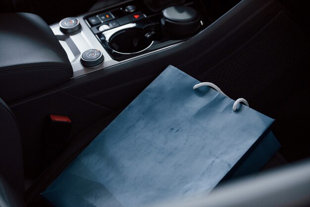 Синяя сумка, лежащая в машине. Крупным планом вид интерьера нового современного роскошного автомобиля