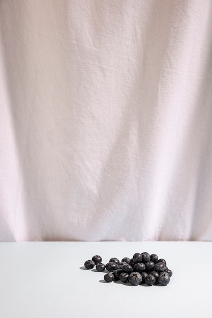 Бесплатное фото Синие ягоды на столе перед белым столом