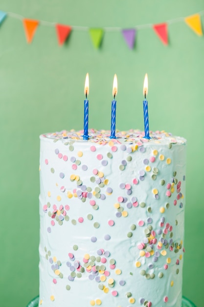 Free photo blue birthday cake with lit candles