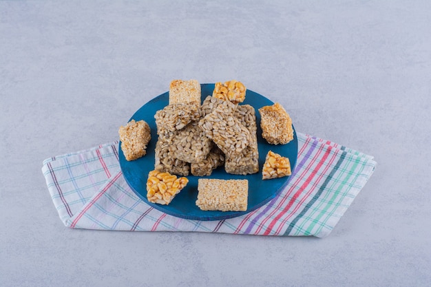 Blue board of candies with various nuts and seeds on stone.