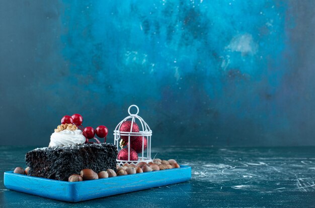 チョコレートケーキとマカダミアナッツが入った青いボード。高品質の写真