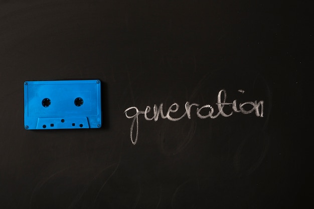 Blue cassette tape and generation word on black background