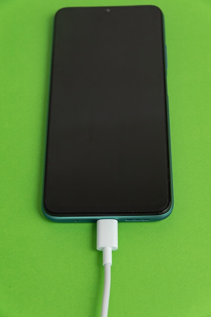 Free photo blue cell phone connected to usb cable type c - charging