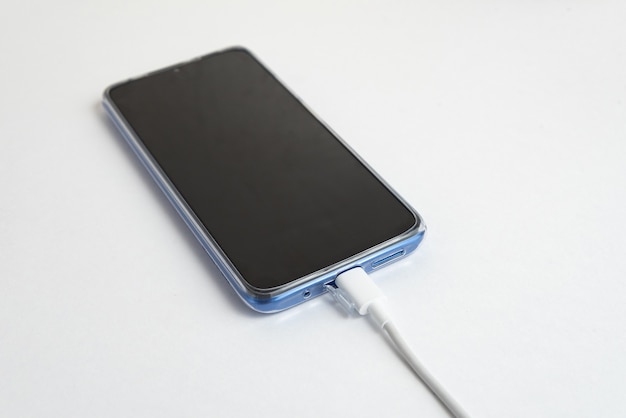 Blue cell phone connected to USB cable type - Charging