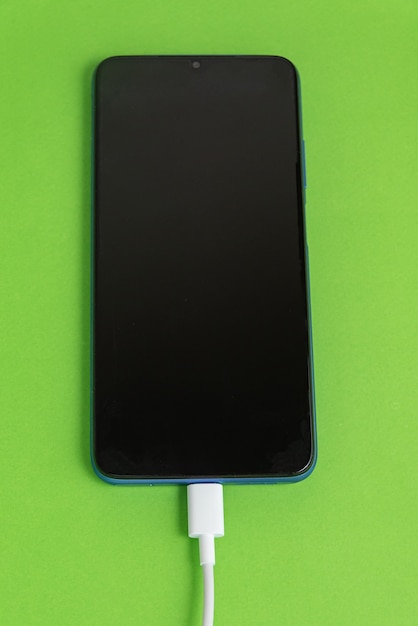 Blue cell phone connected to USB cable type - Charging