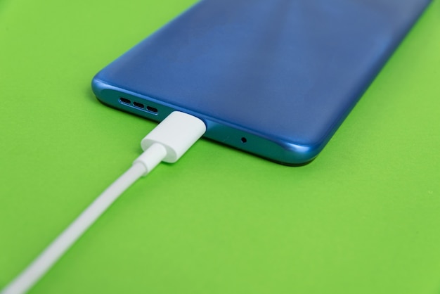 Blue cell phone connected to USB cable type - Charging