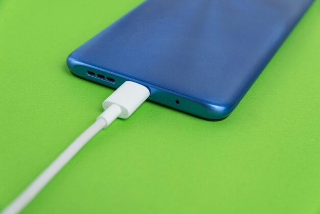 Blue cell phone connected to USB cable type - Charging