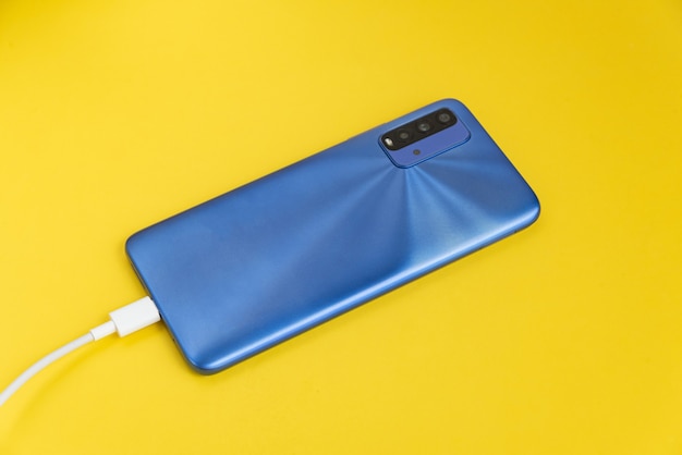 USB 케이블 형태로 연결된 파란색 휴대폰 - 충전 중