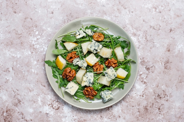 Blue cheese salad with walnut and ruccola and olive oil and pear slices