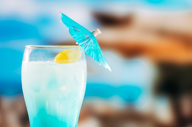 Blue chilled drink in glass decorated with umbrella