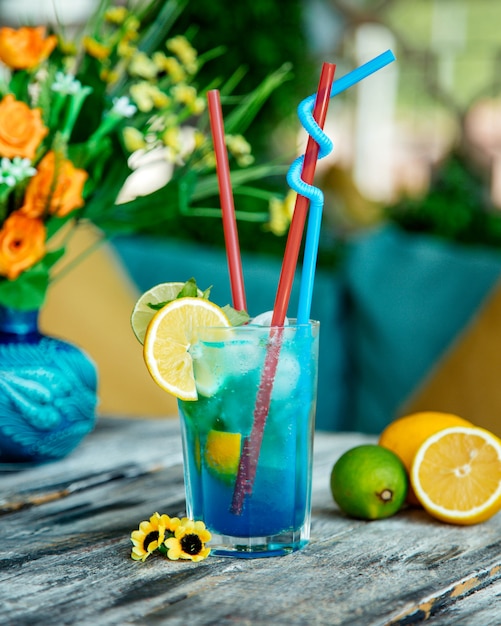 Blue cocktail glass with lime and lemon