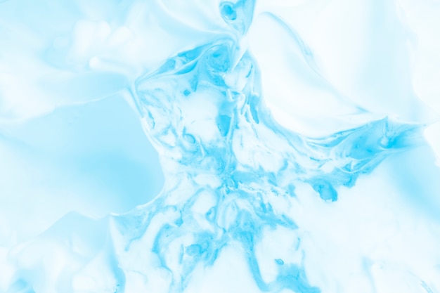 白いクリーミーな泡の表面に青い色の塗料がミックス